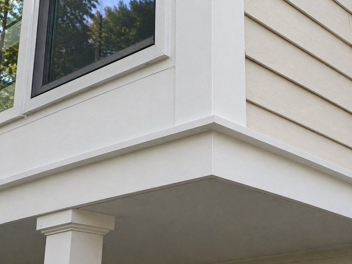 Wood trim after carpentry repair — rebuilt corner with fresh paint and clean lines